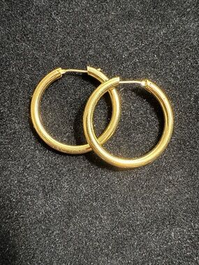 Classic gold-tone hoop earrings, approximately 1 inch in diameter.
